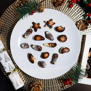 Belgian Chocolate Seashells on a plate with Christmas decorations around it